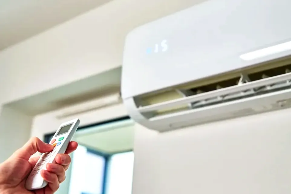 Persona ajustando la temperatura de su vivienda climatizada con aerotermia
